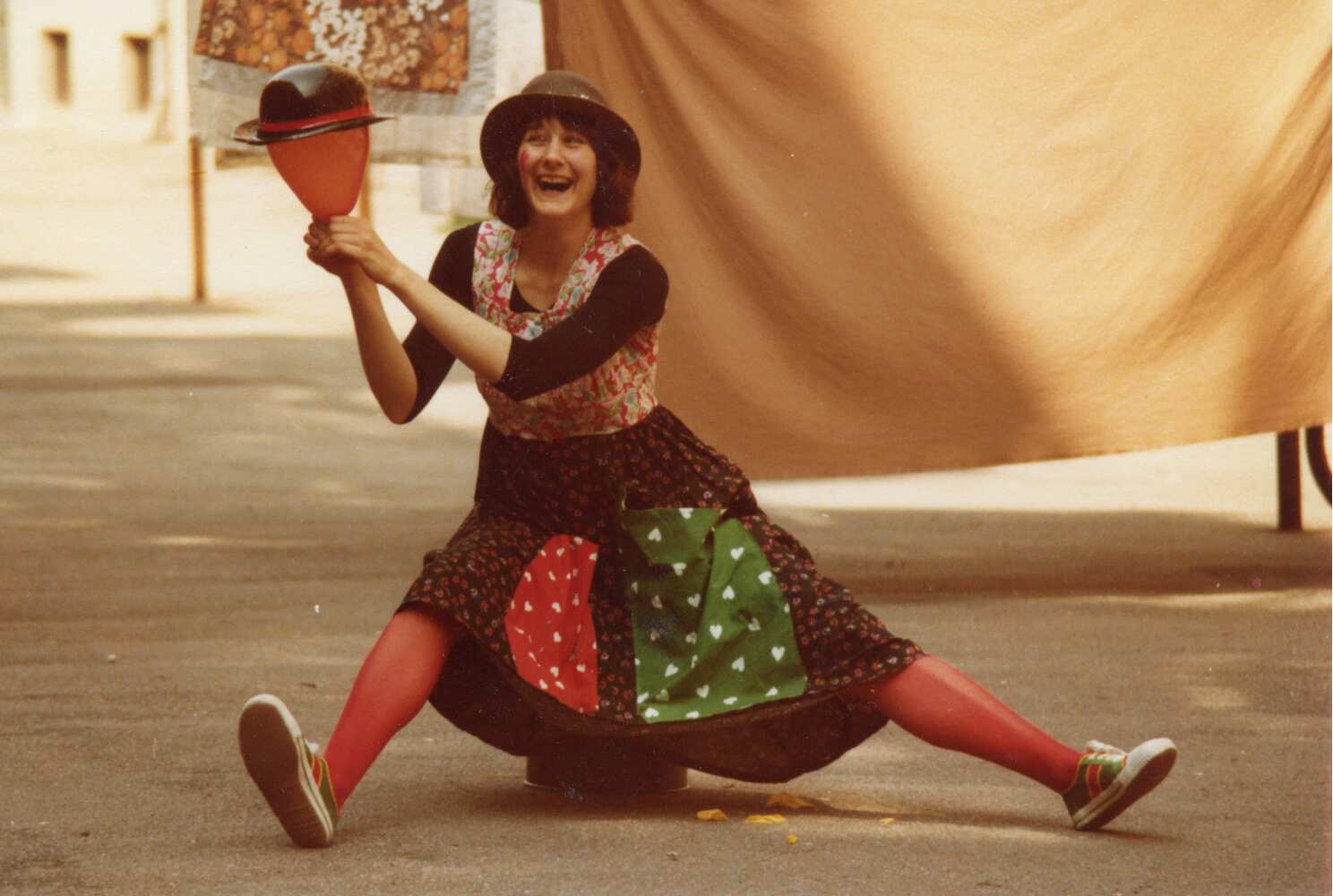 Victoria Millard clowning with a balloon wearing a hat