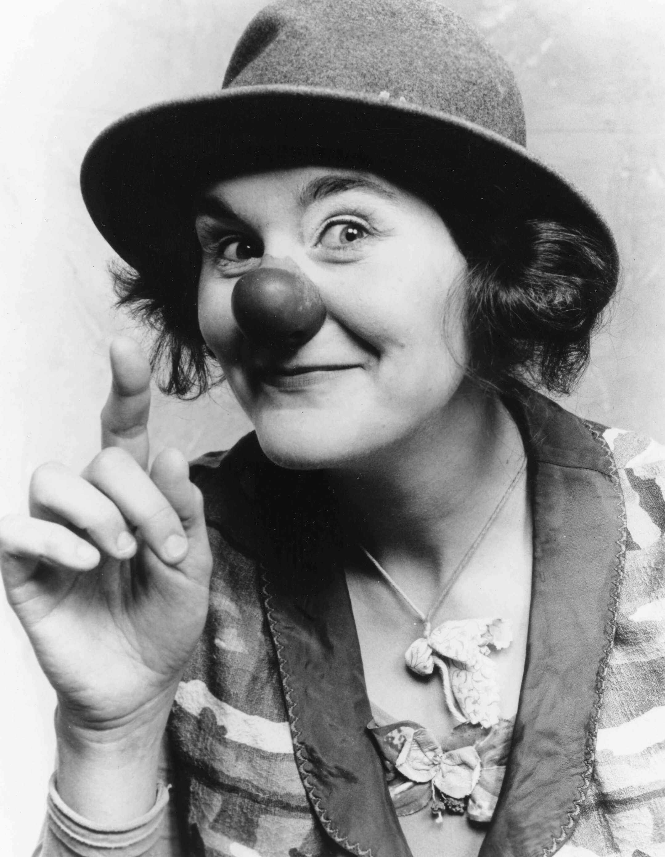 Black & white theatrical headshot of Victoria Millard wearing a hat and clown nose